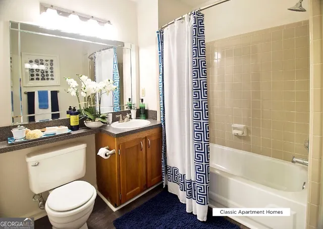 a bathroom with a sink a toilet a mirror and shower