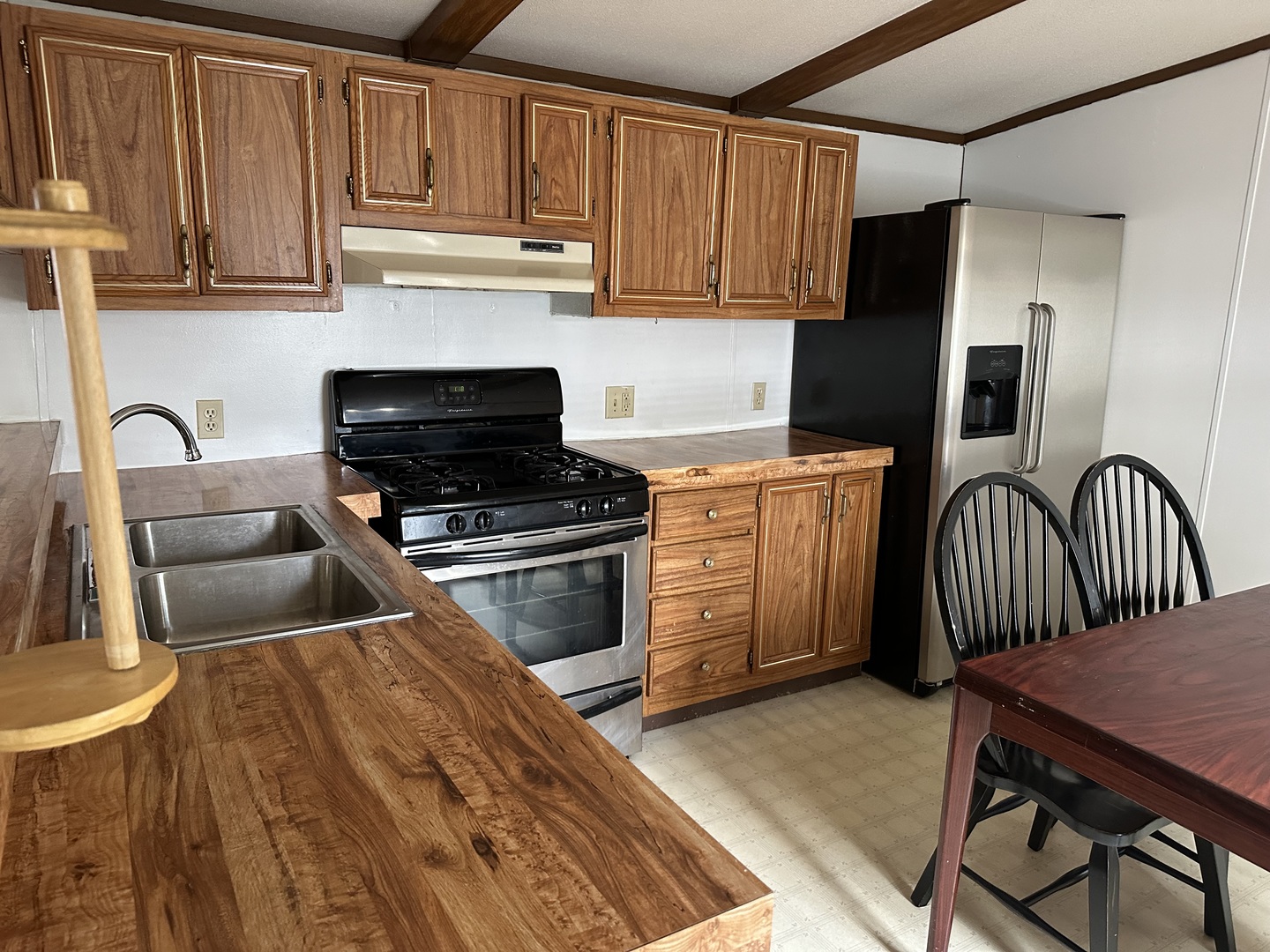 10557 North State Rte 50, Unit 11 Manteno, IL 60950 - Photo 7 of 11 a kitchen with stainless steel appliances granite countertop a stove a sink dishwasher and cabinets with wooden floor