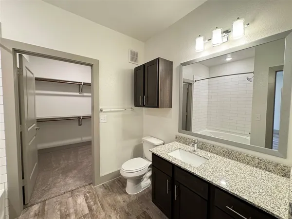 a bathroom with a granite countertop sink toilet and shower