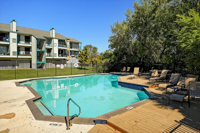 a view of swimming pool with outdoor seating and a garden