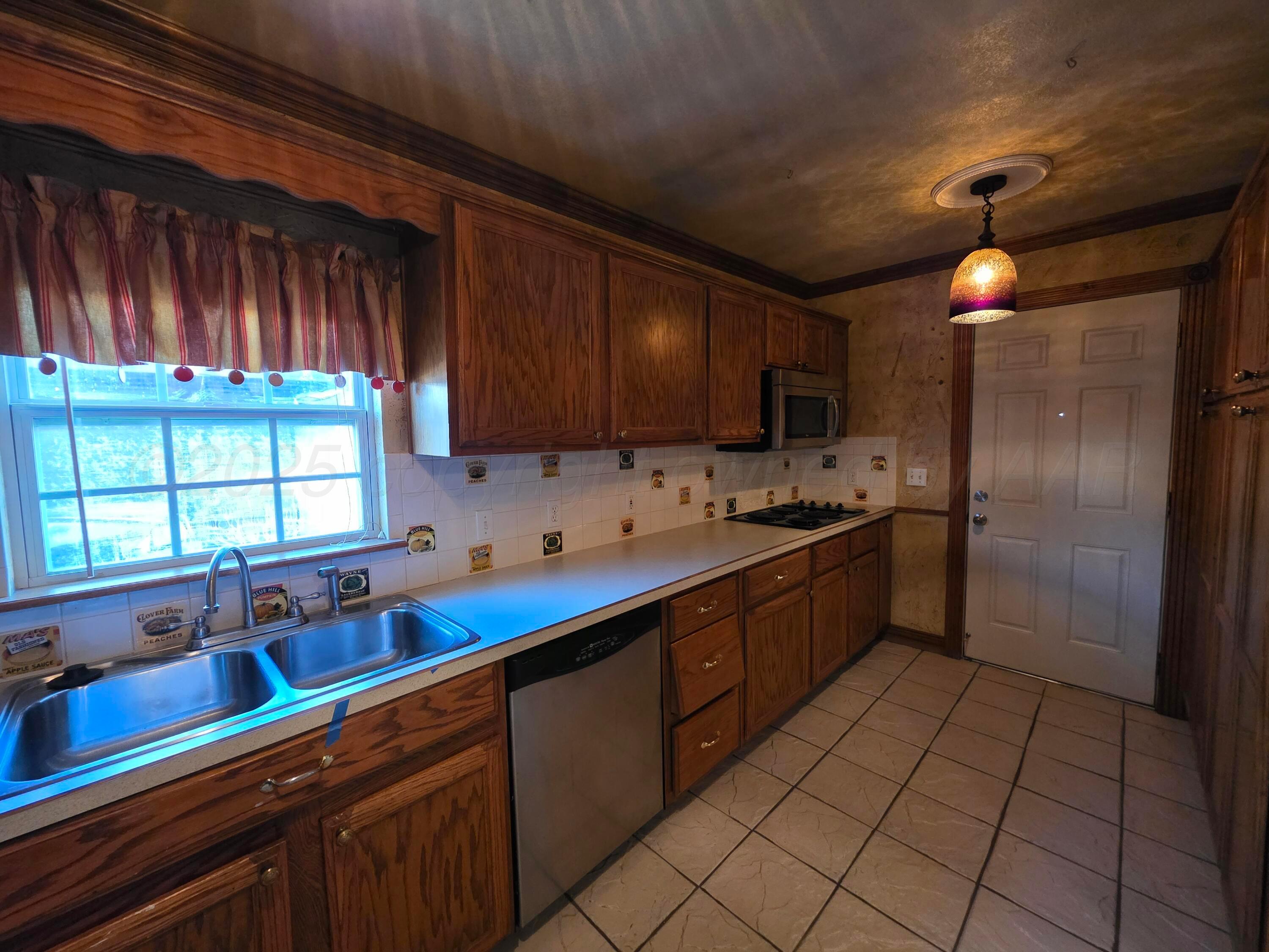 3609 South Jackson Street Amarillo, TX 79110 - Photo 9 of 30 a kitchen with a sink cabinets and window