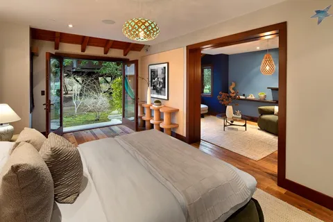 a bedroom with a bed and large windows