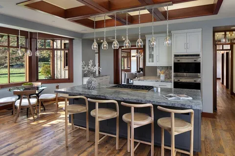 a kitchen with a dining table chairs and refrigerator