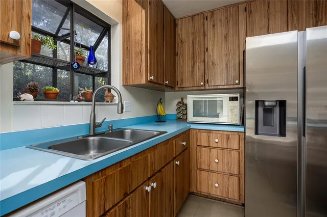 a kitchen with stainless steel appliances granite countertop a sink and a refrigerator