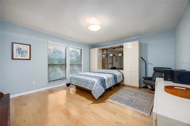 a bedroom with a bed flat screen tv and window