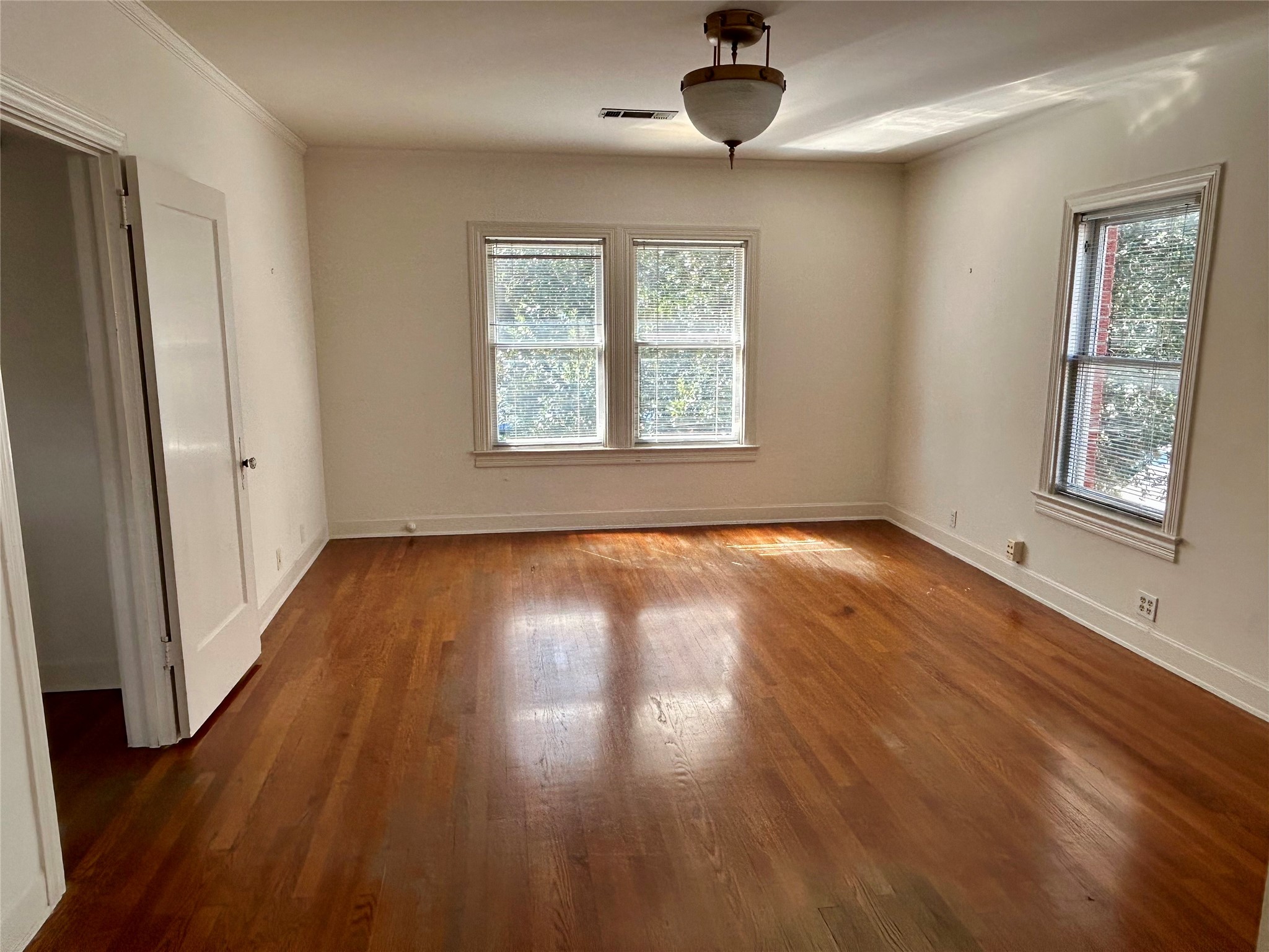 2038 Lexington Street Houston, TX 77098 - Photo 15 of 21 a view of an empty room with wooden floor and a window