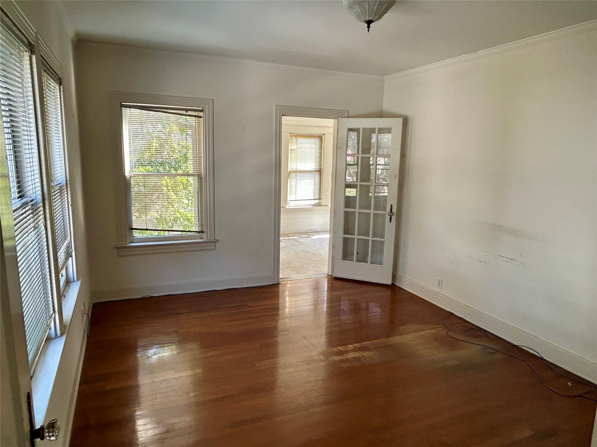 2038 Lexington Street Houston, TX 77098 - Photo 18 of 21 an empty room with wooden floor and windows