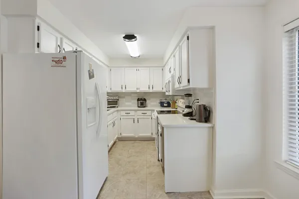 a kitchen with stainless steel appliances granite countertop a sink a stove and white cabinets