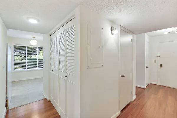 a view of a hallway with bathroom and mirror
