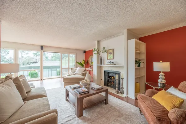 a living room with furniture large window and a fireplace