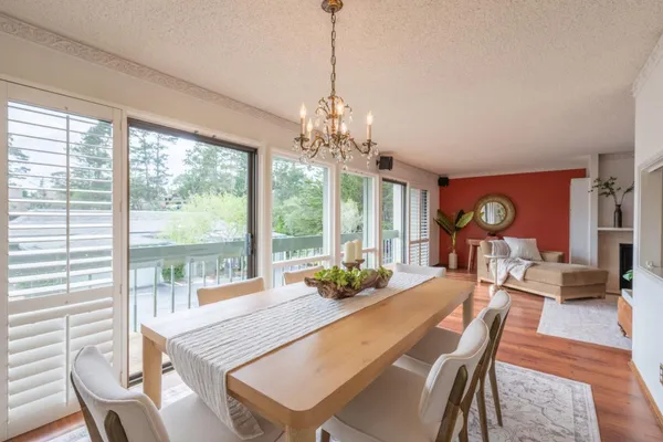 a dining room with furniture large windows and wooden floor