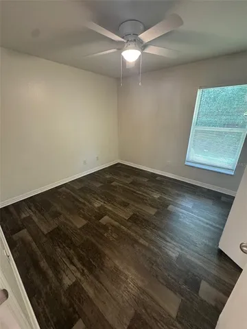 an empty room with wooden floor and white walls