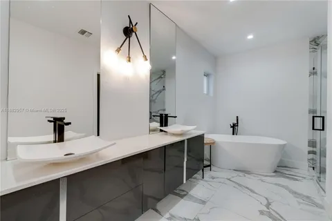 a bathroom with a double vanity sink mirror and bathtub
