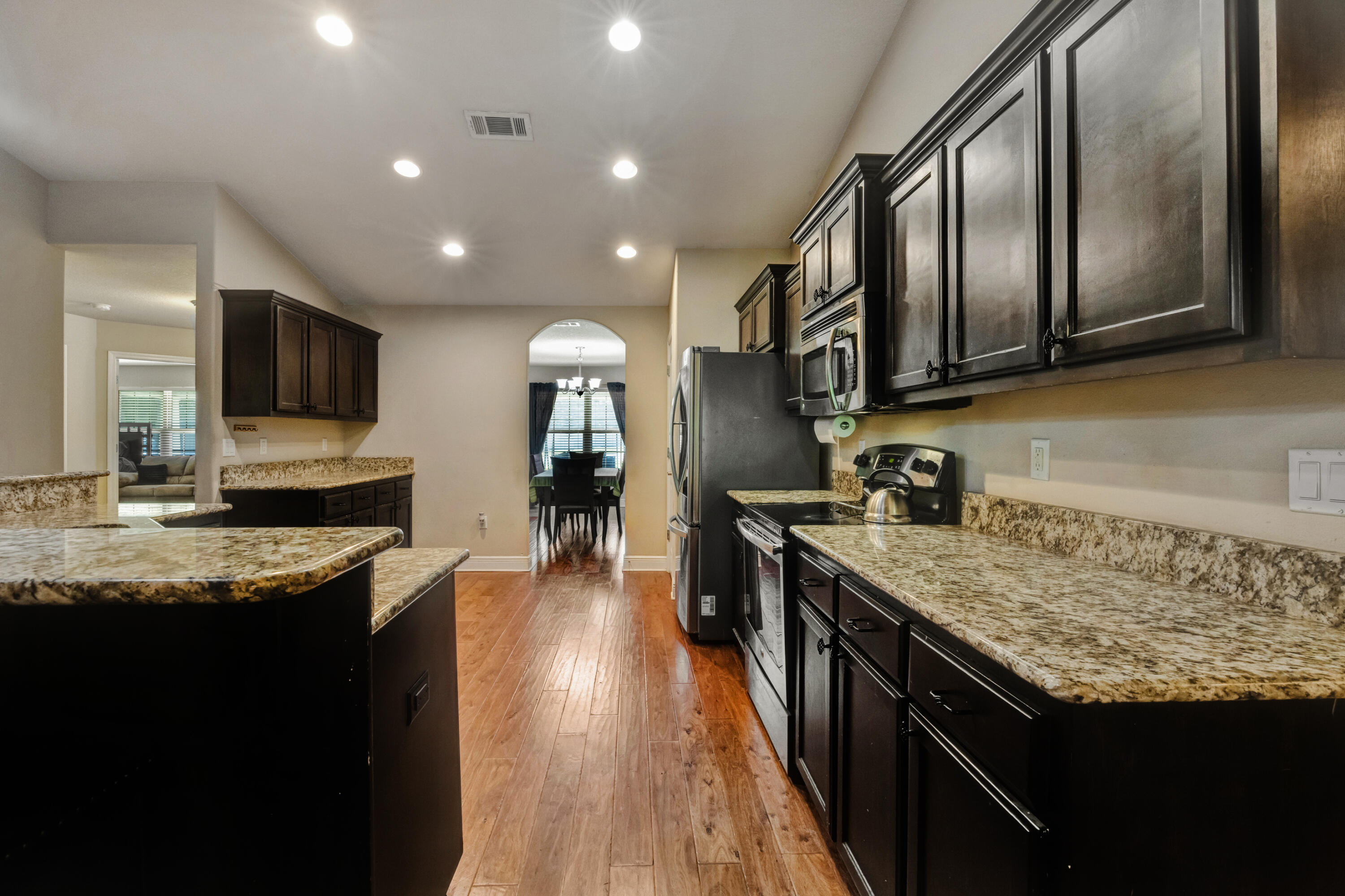 2428 Genevieve Way Crestview, FL 32536 - Photo 16 of 53 a kitchen with granite countertop stainless steel appliances and wooden cabinets