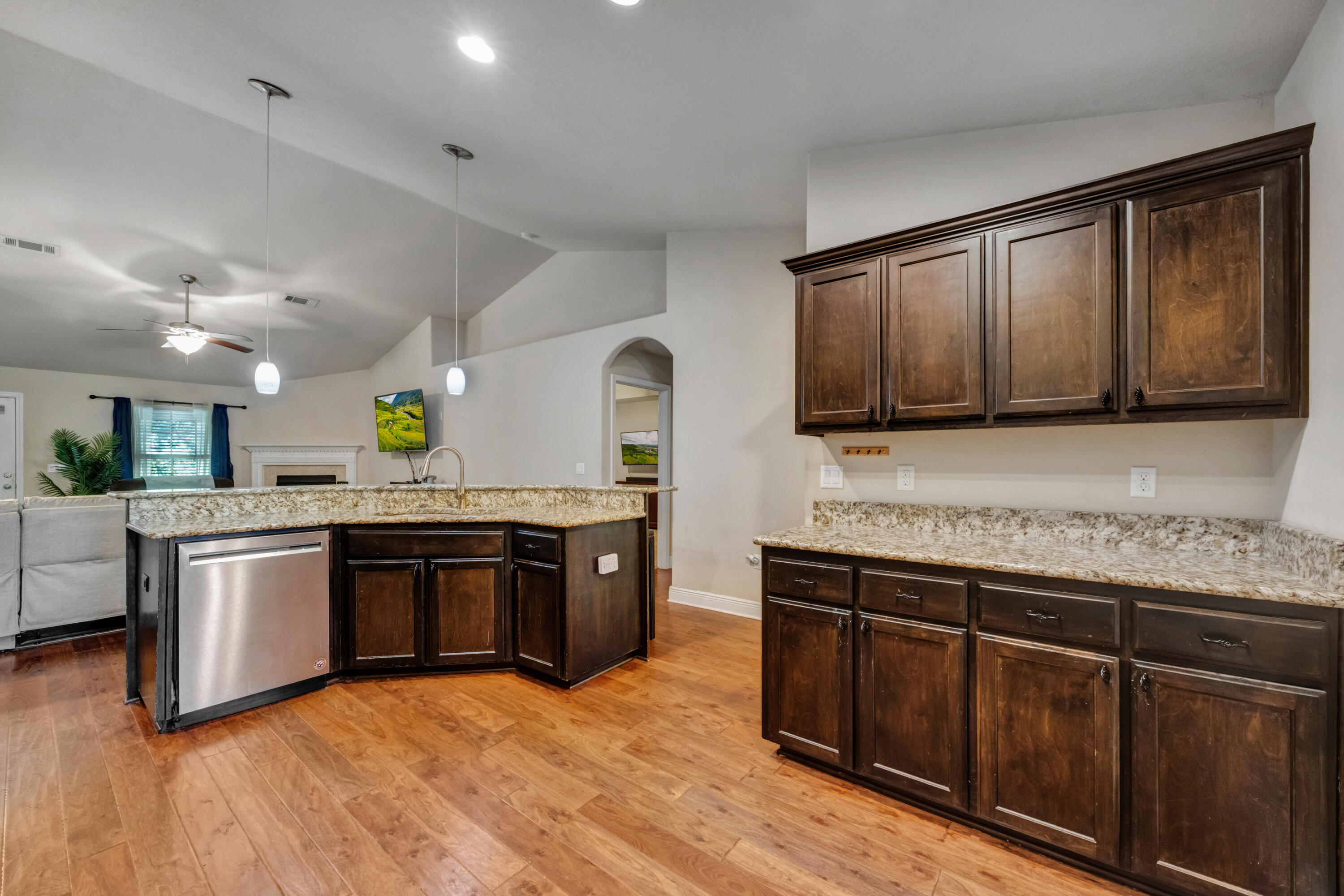2428 Genevieve Way Crestview, FL 32536 - Photo 17 of 53 a large kitchen with stainless steel appliances granite countertop a stove a sink dishwasher and a microwave oven with wooden floor