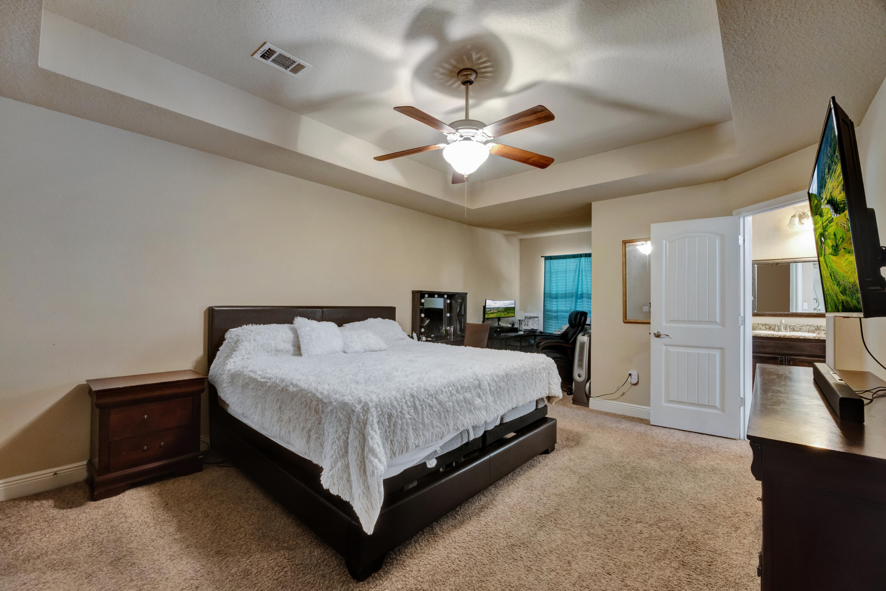 2428 Genevieve Way Crestview, FL 32536 - Photo 23 of 53 a spacious bedroom with a bed and a flat tv screen on dresser