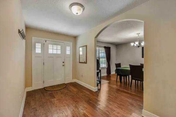 a view of a hallway with wooden floor and closet