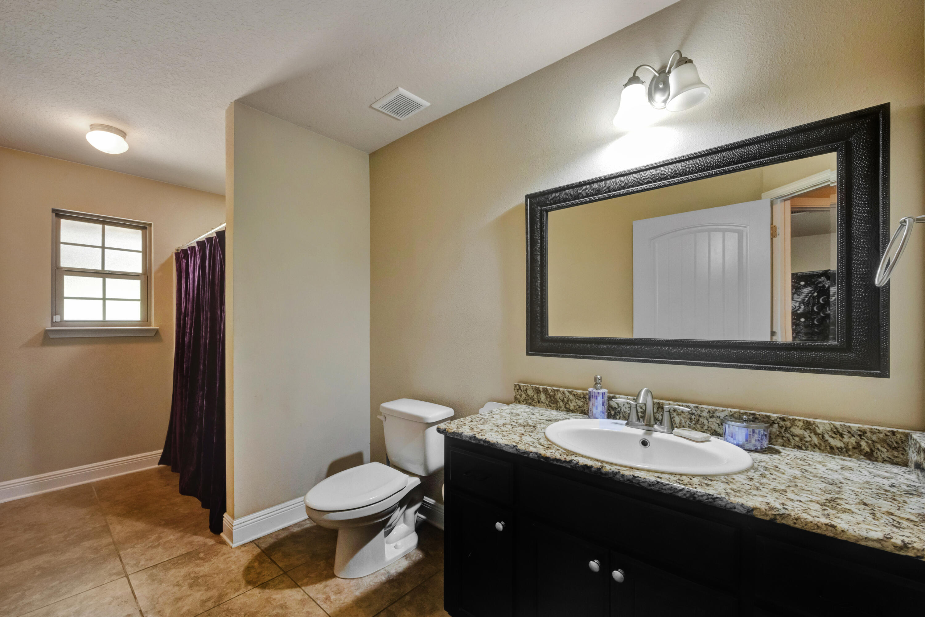 2428 Genevieve Way Crestview, FL 32536 - Photo 36 of 53 a bathroom with a granite countertop sink toilet and mirror