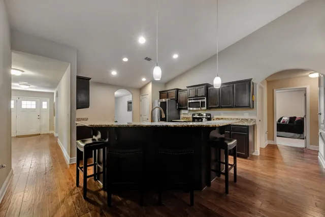 a kitchen with stainless steel appliances granite countertop a sink a stove and a refrigerator