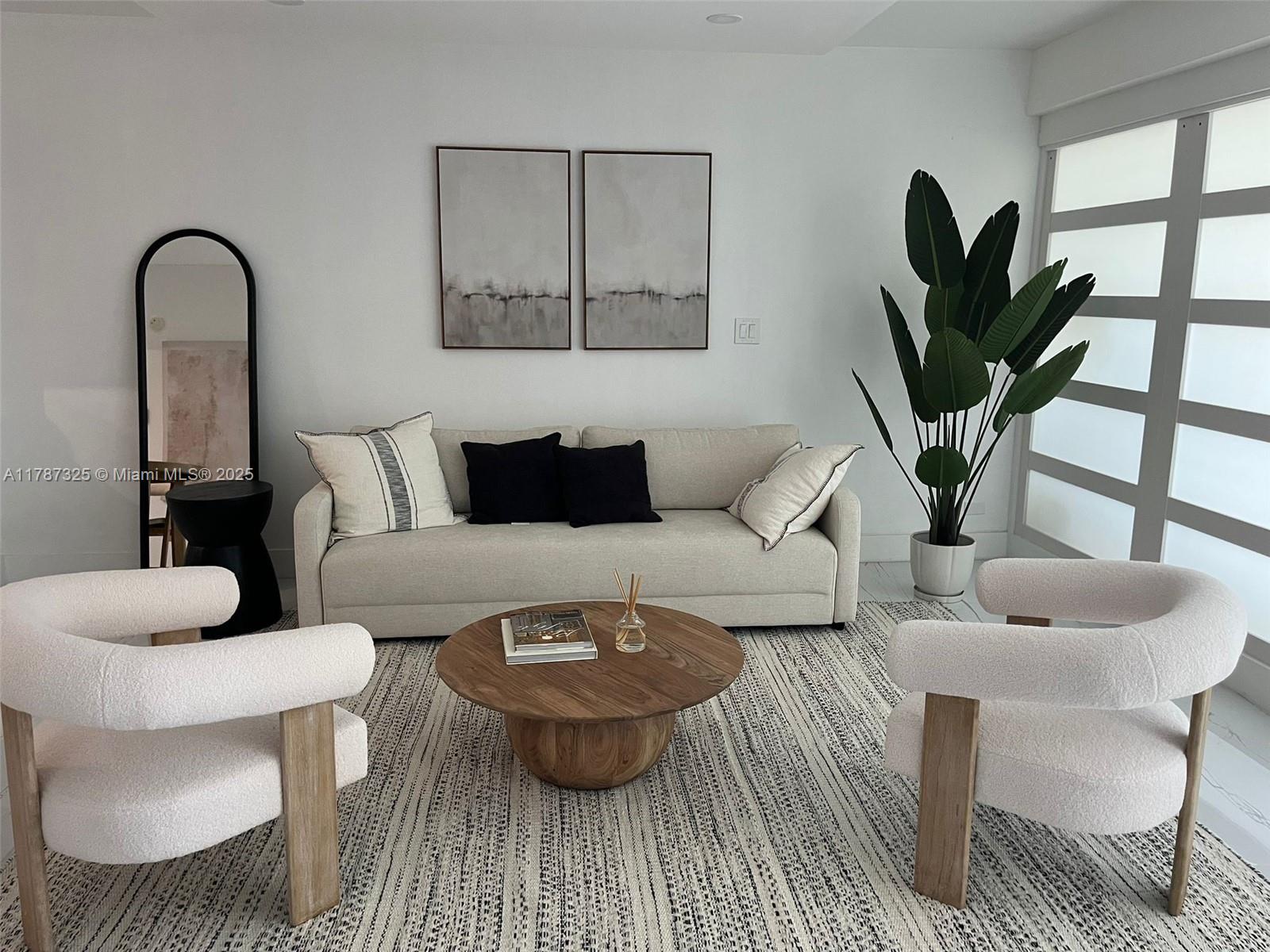 a living room with furniture a potted plant and a painting on the wall