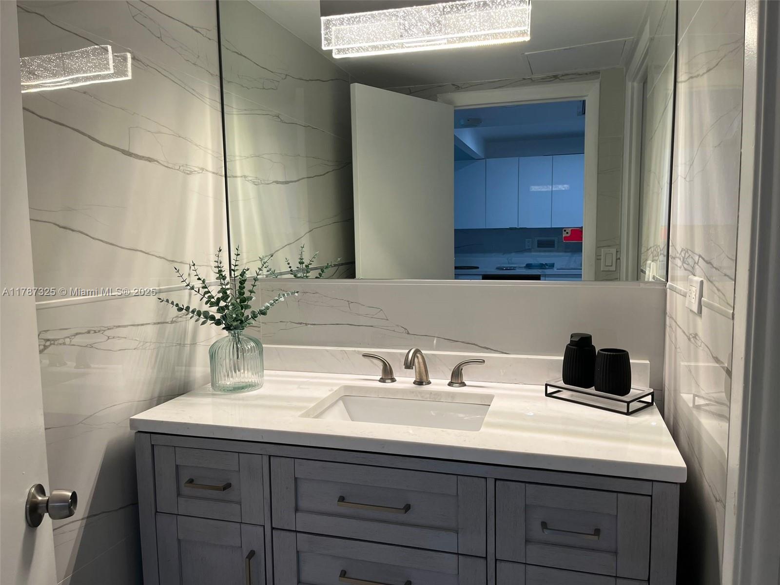 2301 Collins Avenue, Unit 628 Miami Beach, FL 33139 - Photo 12 of 25 a bathroom with a sink and a mirror