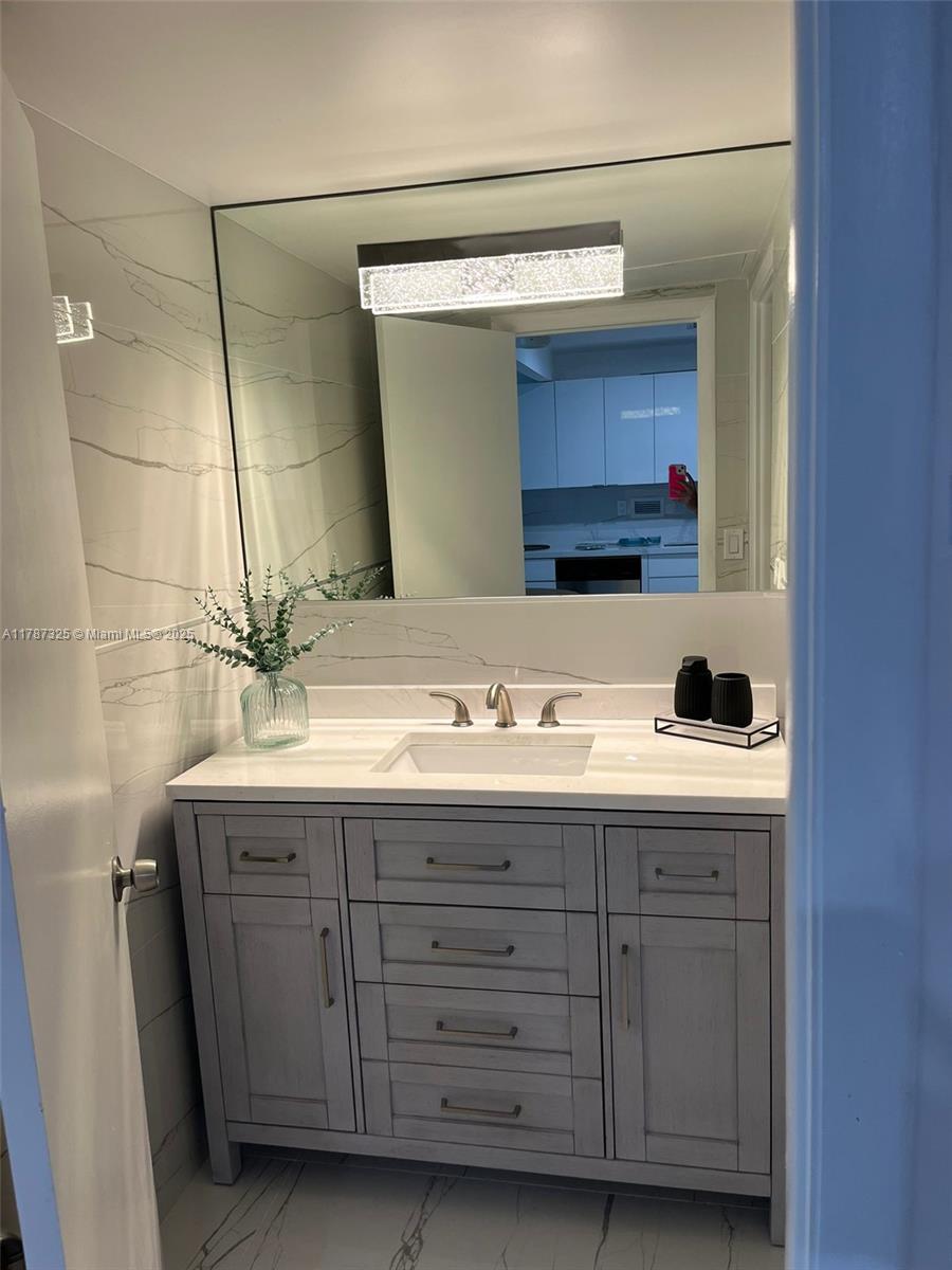 2301 Collins Avenue, Unit 628 Miami Beach, FL 33139 - Photo 9 of 25 a bathroom with a sink and a mirror