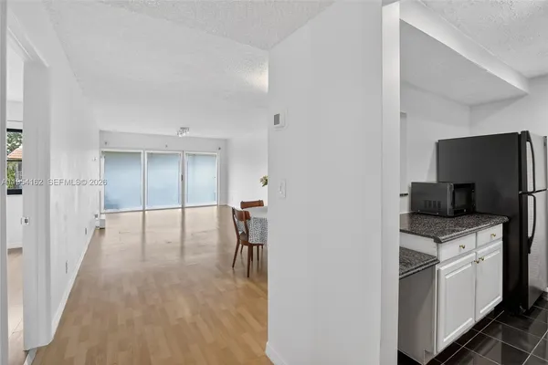 a hallway with a computer on a desk and wooden floor