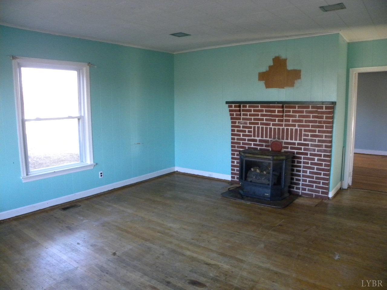 5797 Scuffletown Road Randolph, VA 23962 - Photo 5 of 18 a living room with a fireplace and wooden floor