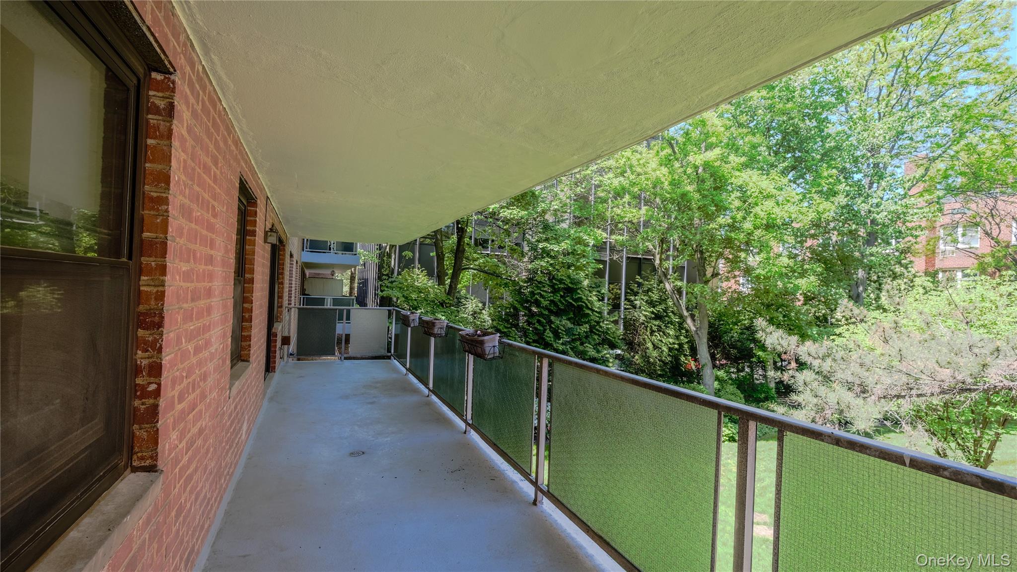 20 Canterbury Road, Unit 1P Great Neck, NY 11021 - Photo 10 of 28 Large Covered Patio Overlooking Grassy Courtyard