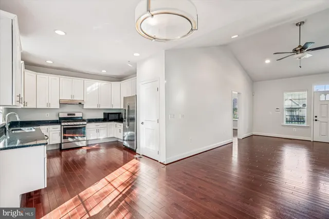 a kitchen with granite countertop white cabinets and appliances