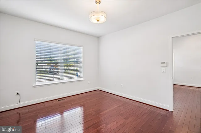 a view of empty room with wooden floor