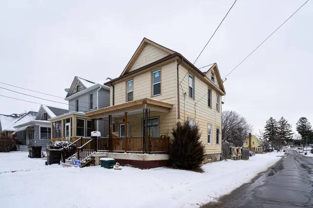 a view of a house with a yard covered in snow