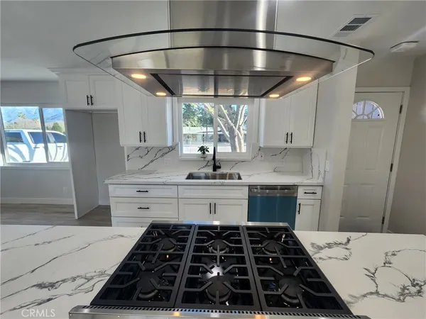 a kitchen with a large stove a sink and cabinets