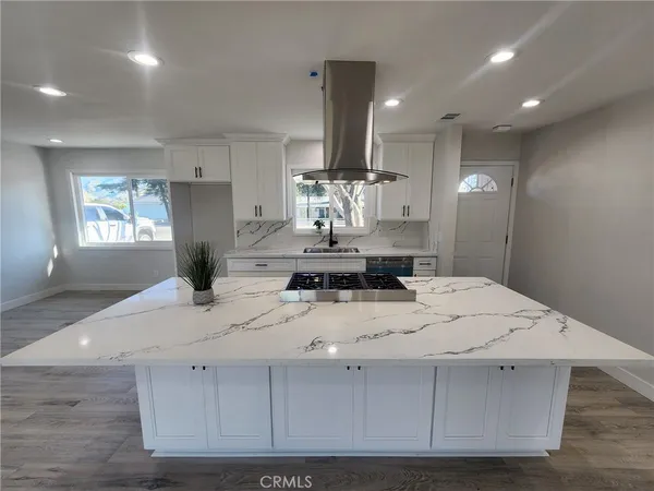 a large kitchen with kitchen island a stove a sink dishwasher and refrigerator with wooden floor