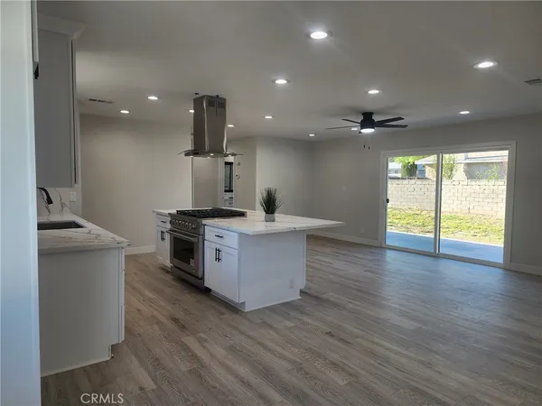 a kitchen with stainless steel appliances a sink and wooden floor