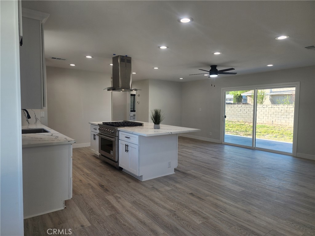 693 West Wilson Street Banning, CA 92220 - Photo 27 of 48 a kitchen with stainless steel appliances a sink and wooden floor