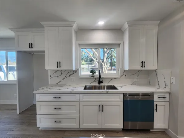 a kitchen with cabinets appliances a sink and a window