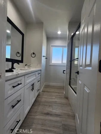 a bathroom with double vanity and a mirror