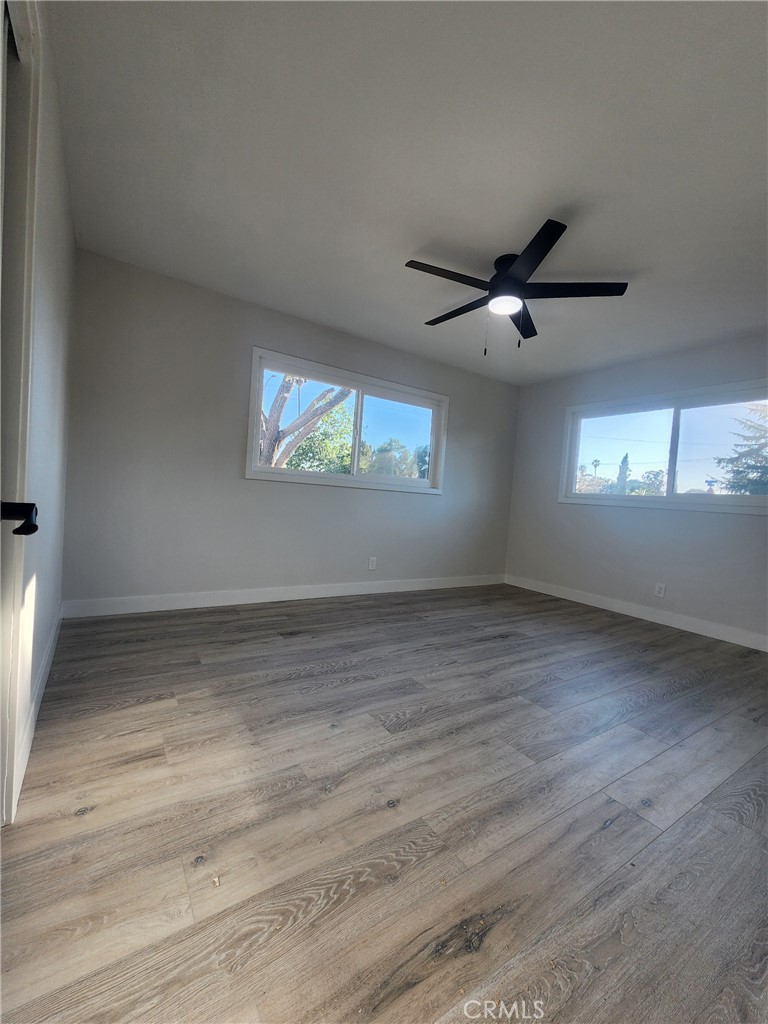 693 West Wilson Street Banning, CA 92220 - Photo 42 of 48 an empty room with wooden floor and windows