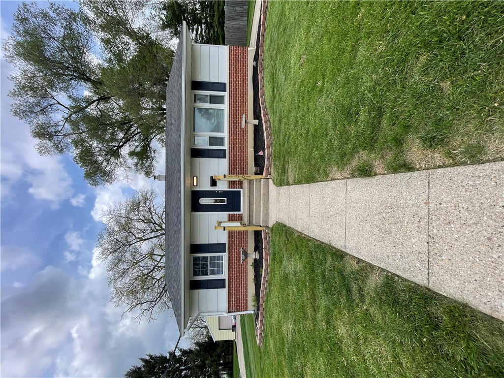1361 Sussex Road Troy, OH 45373 - Photo 9 of 25 This charming home showcases classic brick and siding construction with a well-maintained lawn.