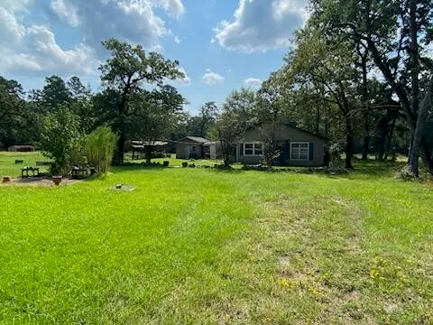 a view of a house with a yard and sitting area