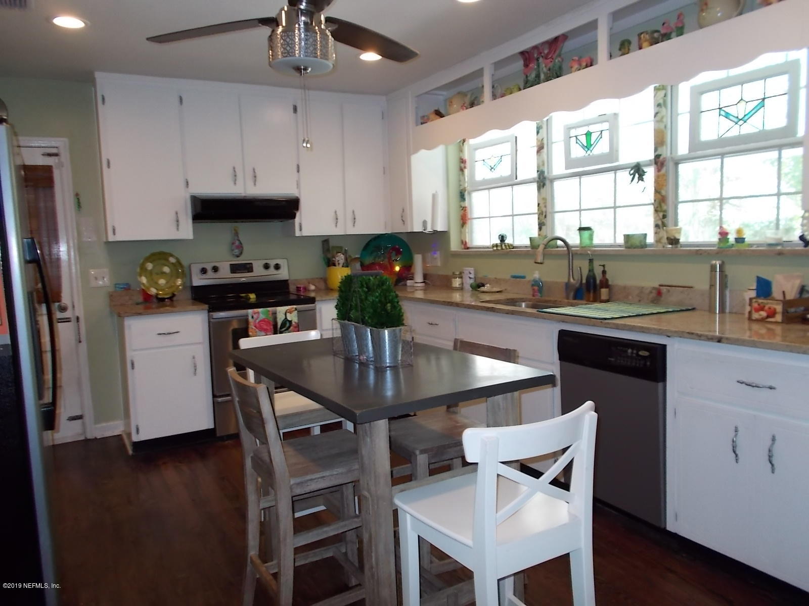 1501 River Bluff Road North Jacksonville, FL 32211 - Photo 6 of 33 a kitchen with stainless steel appliances granite countertop a stove a refrigerator a sink a stove and white cabinets with wooden floor