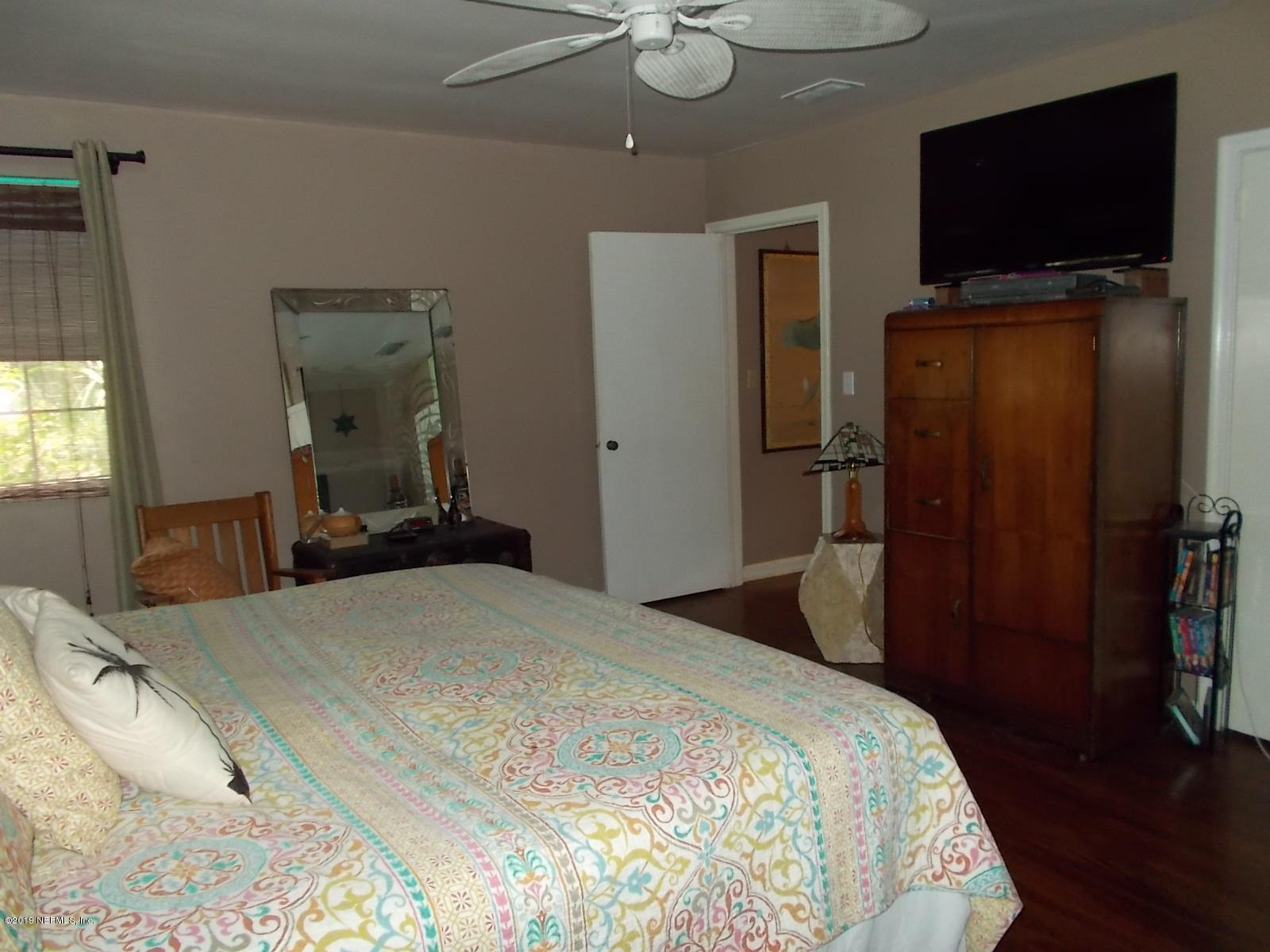 1501 River Bluff Road North Jacksonville, FL 32211 - Photo 10 of 33 a bedroom with a bed and a flat tv screen on wall