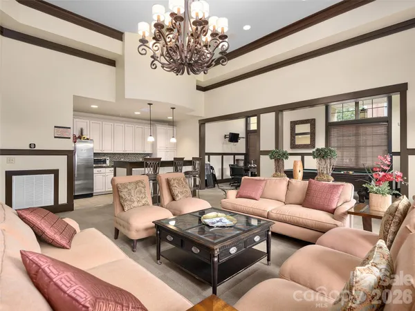 a living room with furniture kitchen view and a chandelier