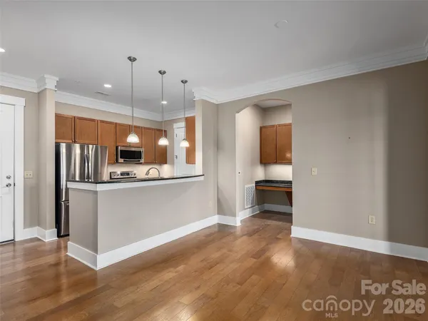 a view of kitchen with kitchen island wooden floor and refrigerator