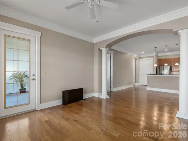 a view of a livingroom with wooden floor and a kitchen space