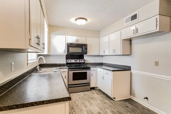 a kitchen with granite countertop a stove and a sink