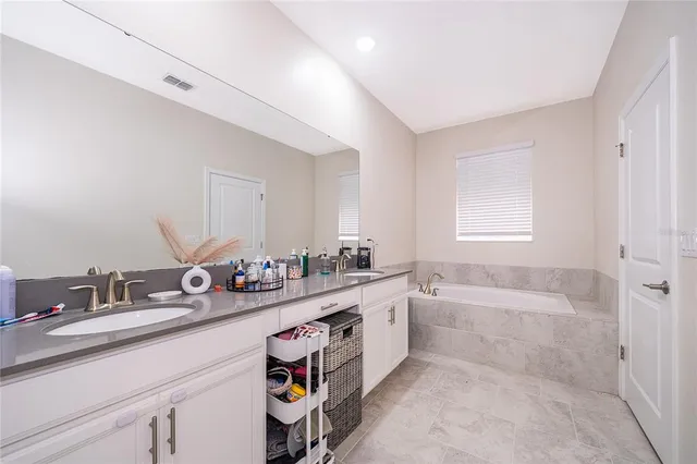 a bedroom with a bed a couch and a flat tv screen