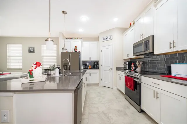 a kitchen with stainless steel appliances kitchen island granite countertop a dining table and chairs