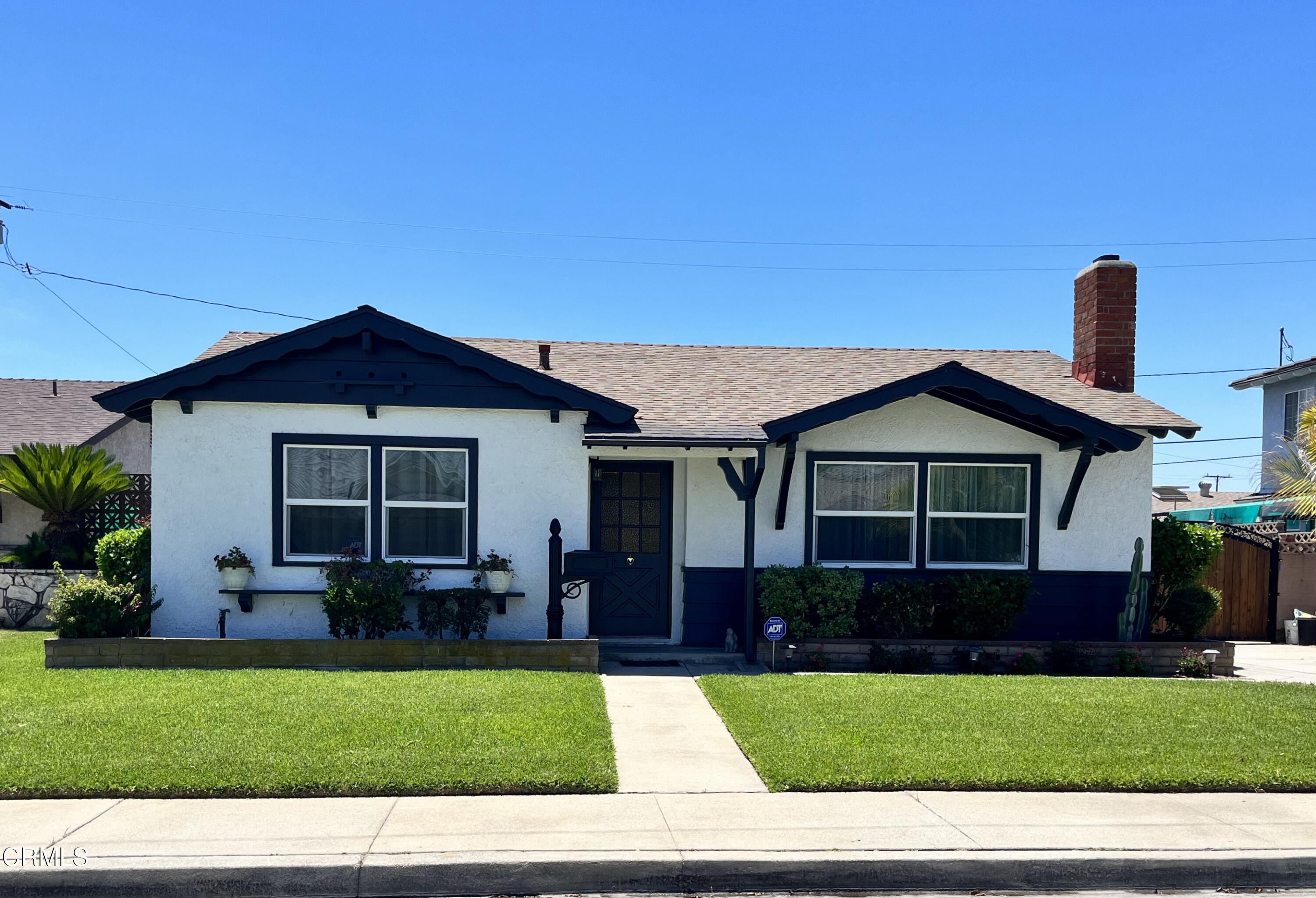 a front view of a house with a garden and yard